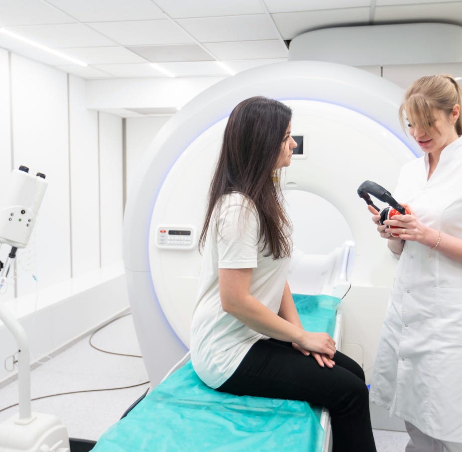 Technician performing eye exam using advanced medical technology with real-time monitoring.